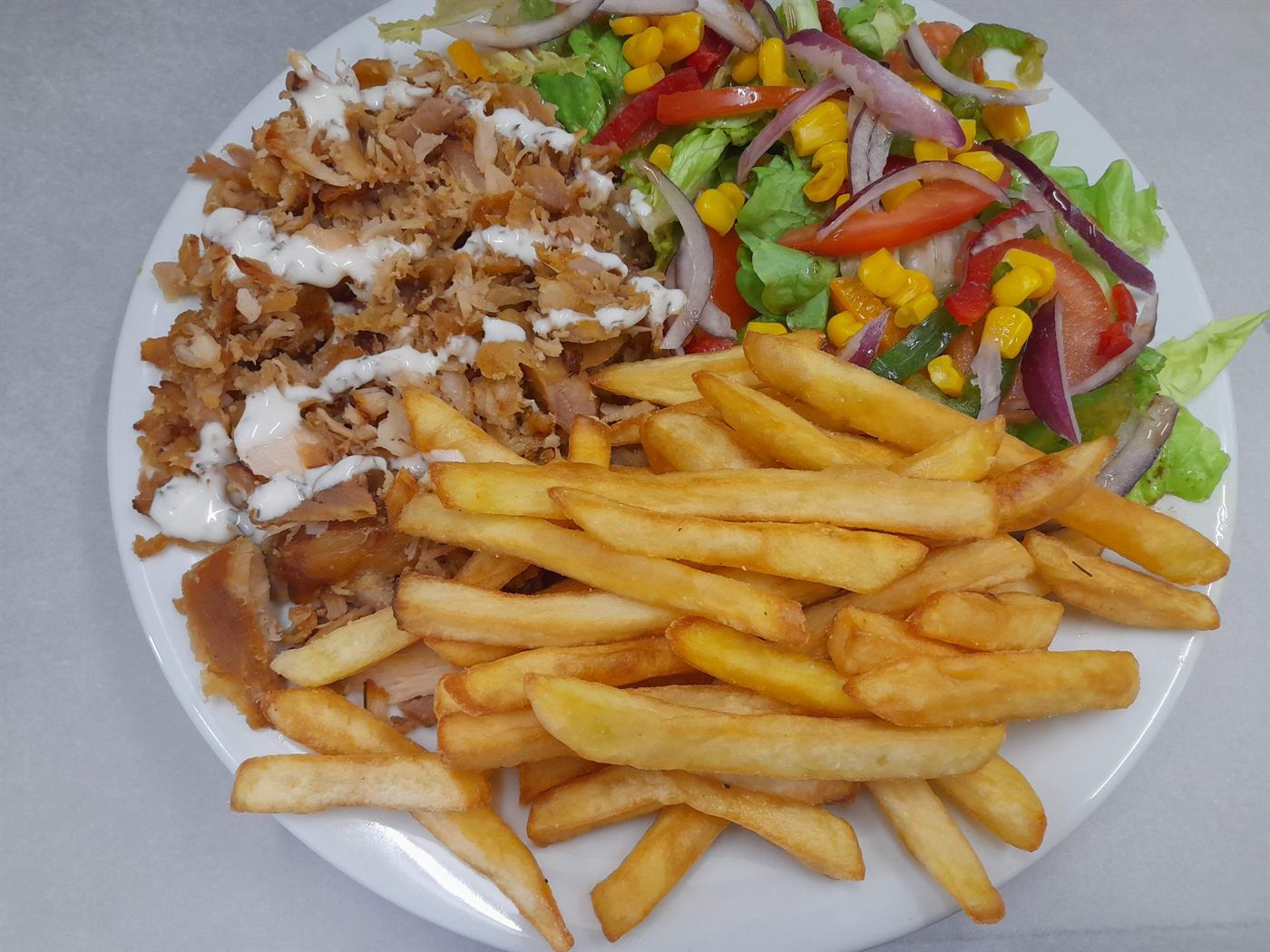 Assiette de kebab, frites, crudités et sauce blanche