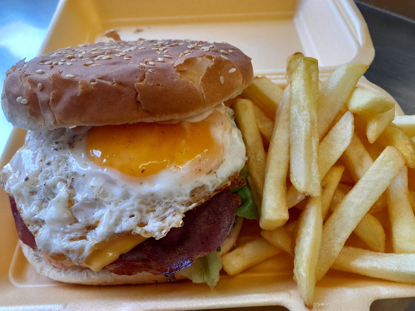 Burger généreux avec œuf, bacon et frites
