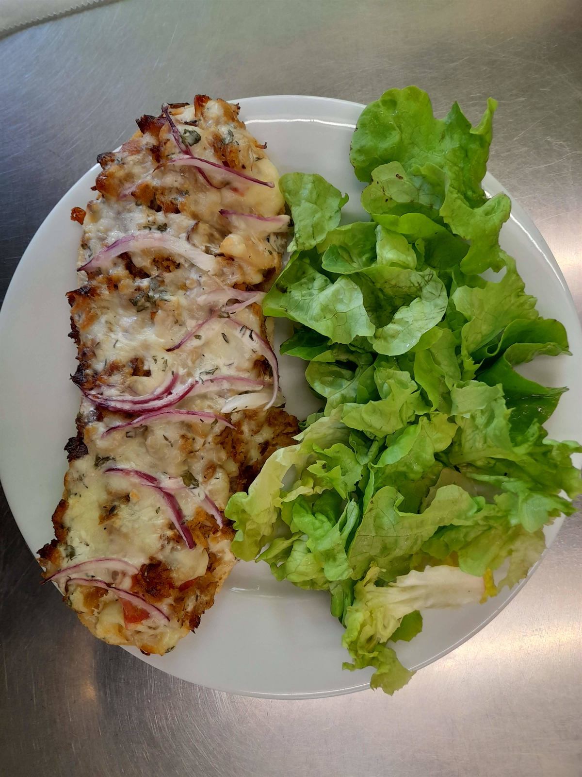 Galette gratinée aux oignons, servie avec une salade verte